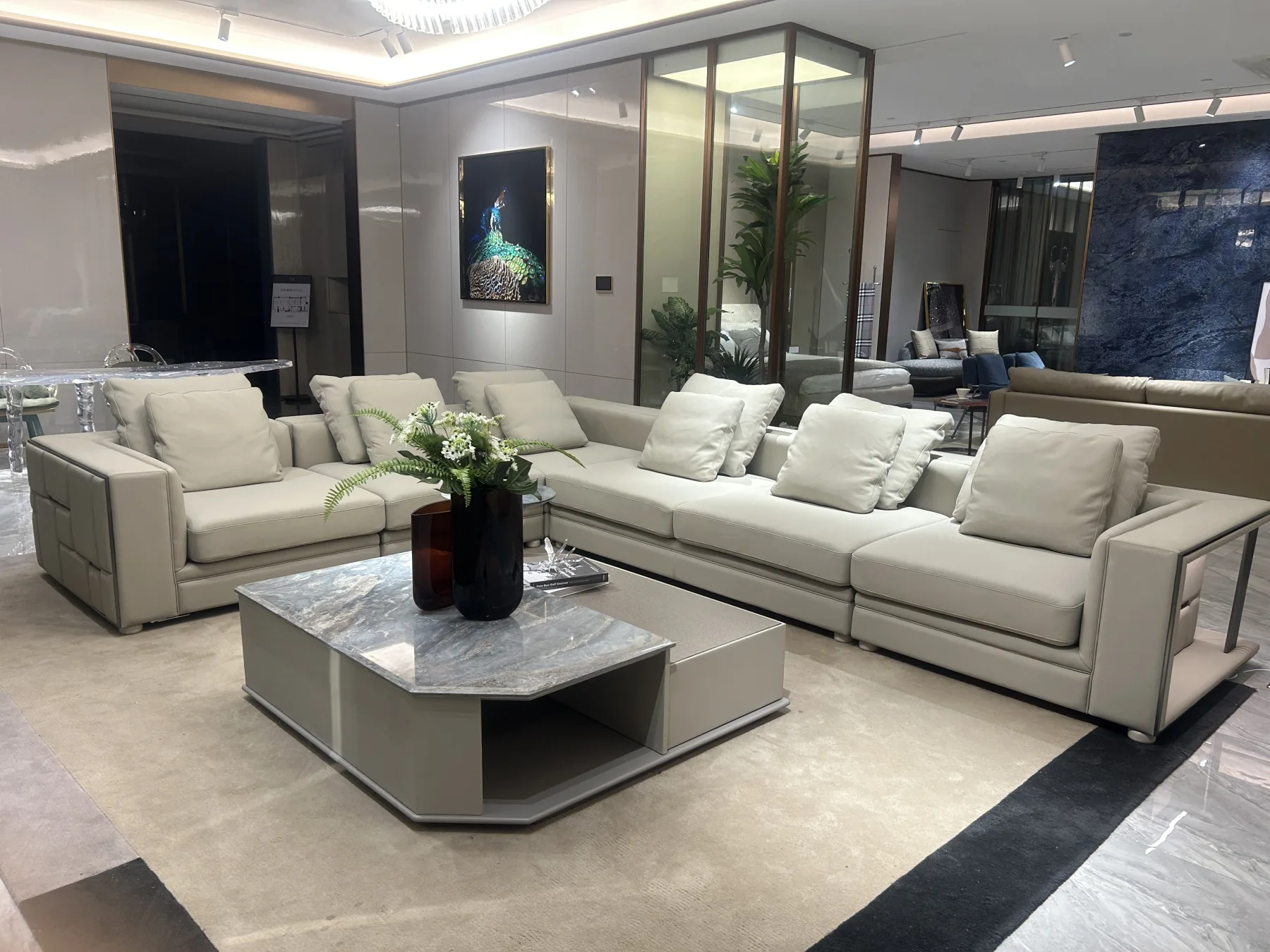Contemporary showroom living room with a cream sectional sofa and stone coffee table